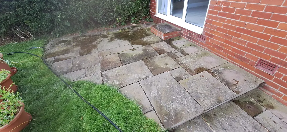 Dirty patio slabs with moss and algae before cleaning